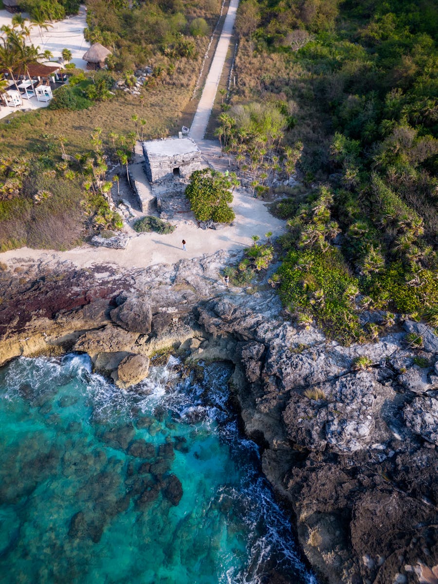 Stunning aerial view of rocky coastline in Cancún, Mexico with turquoise waters.